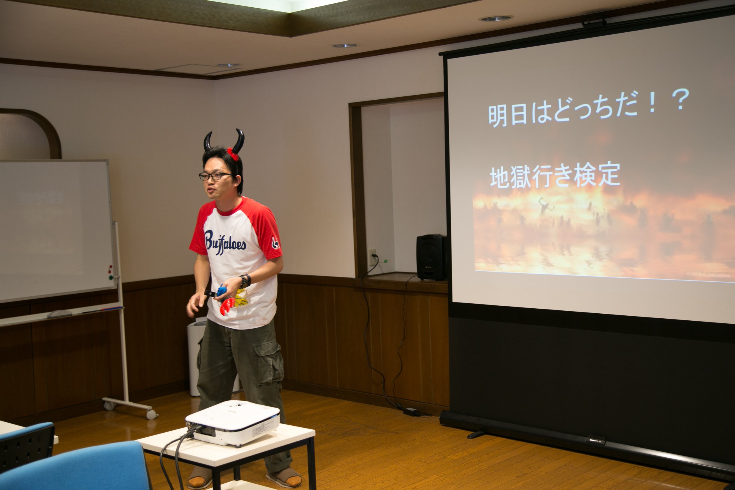 パワポや幹事（閻魔大王様、悪魔１、悪魔２、悪魔３）が検定説明をしている様子。労働をさぼっていると矢でつつかれるとかつつかれないとか。