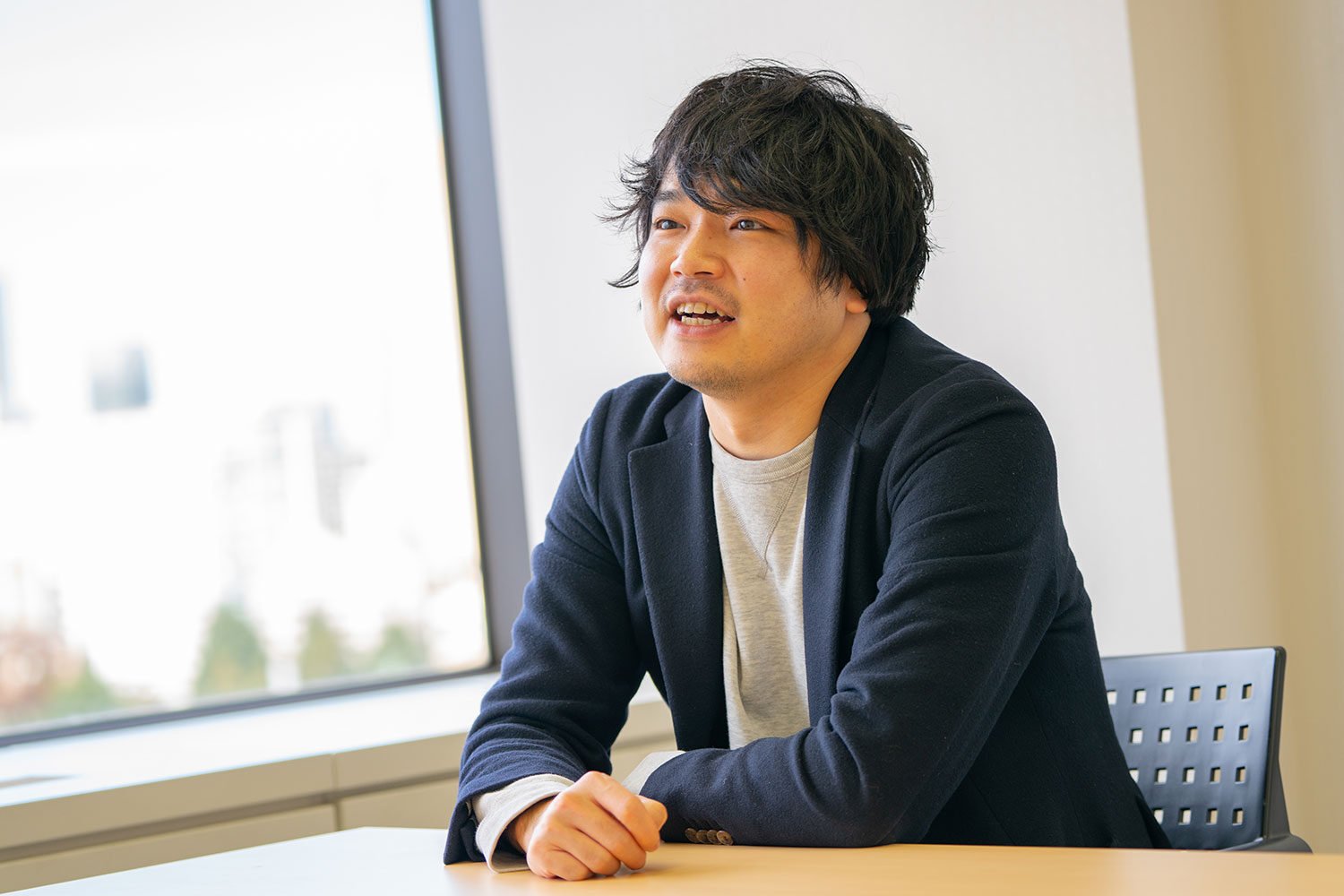 会議室で笑顔を交えながらインタビューに応じる佐賀文昭さん